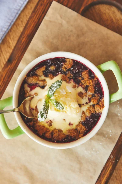 Berry crumble served in pot with ice cream — Stock Photo