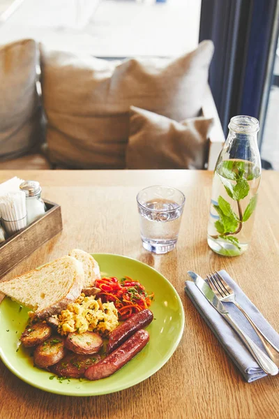 Brunch in restaurant with scramble eggs and sausage — Stock Photo