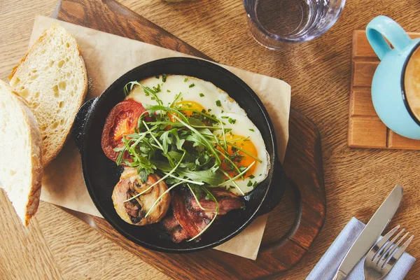 Petit déjeuner avec œufs frits servis dans une poêle — Photo de stock