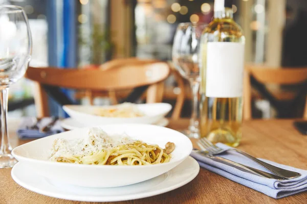 Hot Italian pasta with mushrooms and pesto served with wine — Stock Photo