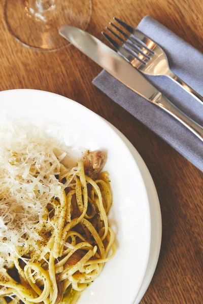 Итальянская паста с грибами и песто подается на белой тарелке — стоковое фото