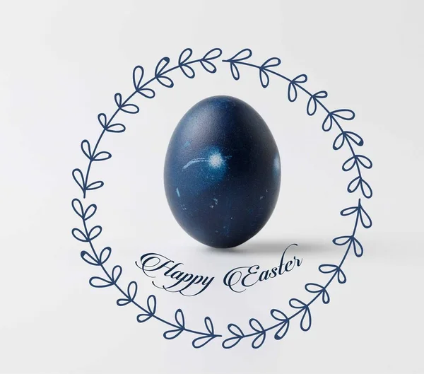 Un uovo di Pasqua dipinto di blu con scritte pasquali felici e ghirlanda floreale su bianco — Foto stock