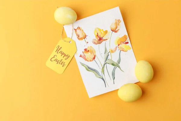 Top view of yellow painted easter eggs with postcard and happy easter lettering on tag on yellow — Stock Photo