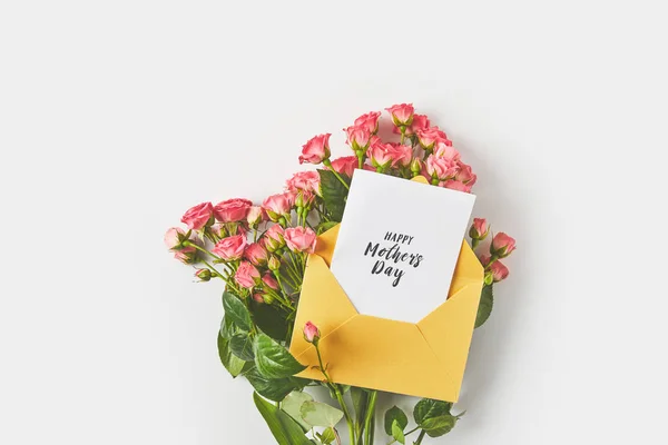 Joyeuse carte de vœux de la fête des mères dans une enveloppe et de belles roses roses sur gris — Photo de stock