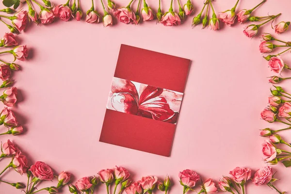 Ansicht des Rahmens aus schönen rosa Rosen und Grußkarte auf rosa — Stockfoto