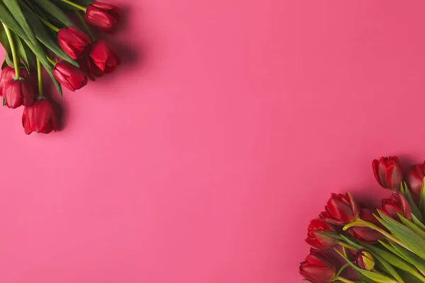 Vue du dessus des bouquets de tulipes rouges sur rose, concept de fête des mères — Photo de stock