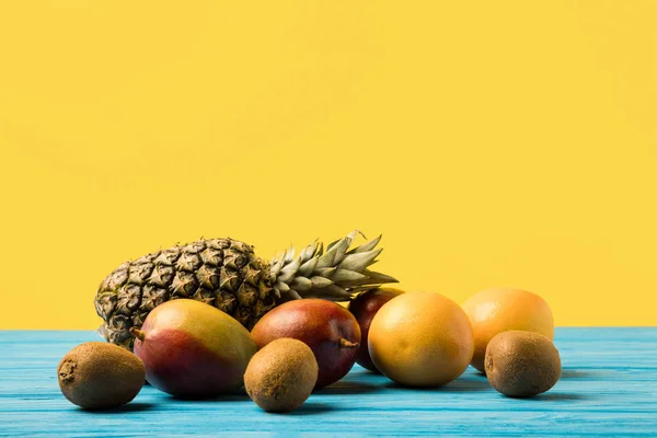 Fresh ripe tropical fruits on turquoise wooden table top — Stock Photo