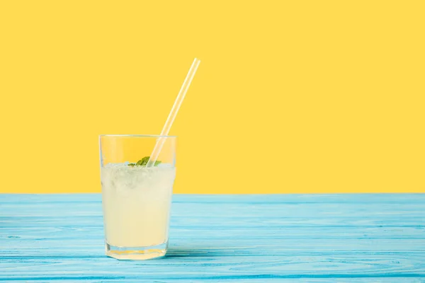 Bebida fria fresca do verão no vidro com palha bebendo na parte superior de tabela de madeira turquesa — Fotografia de Stock