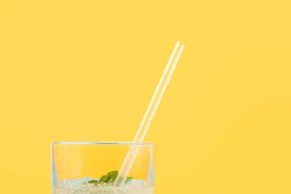 Крупный план стекла со свежим холодным летним коктейлем и соломой, изолированной на желтом — стоковое фото