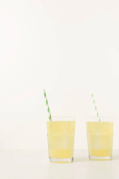 Close-up view of two glasses with fresh tropical cocktail on grey — Stock Photo