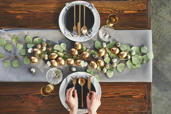 Abgeschnittenes Bild des Kellners, der den Ostertisch im Restaurant dekoriert — Stockfoto