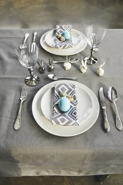 Blick auf bemalte blaue Hühnereier auf Tellern auf dem Tisch — Stockfoto