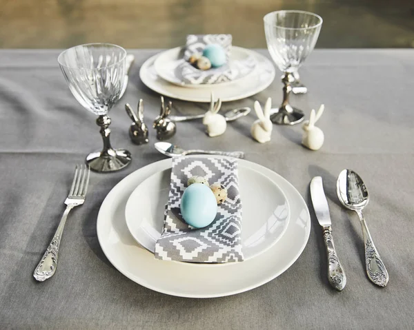 Conejos de Pascua y huevos pintados en la mesa - foto de stock