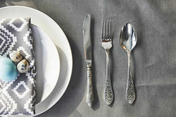 Vue de dessus des oeufs de Pâques sur assiette et ustensile sur table — Photo de stock