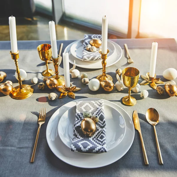 Oeufs de Pâques et bougies sur la table de fête avec la lumière du soleil — Photo de stock