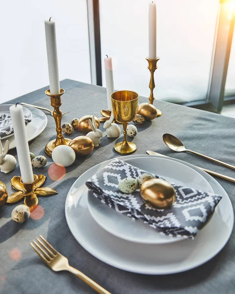 Mesa festiva con huevos de oro y velas, concepto de Pascua - foto de stock