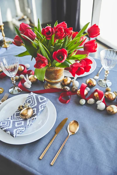 High angle view of bouquet of red tulips and easter eggs on festive table — Stock Photo