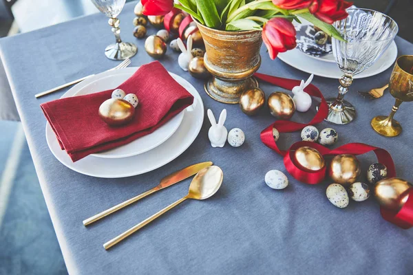 Visão de alto ângulo de ovos de ouro de Páscoa e flores na mesa festiva no restaurante — Fotografia de Stock