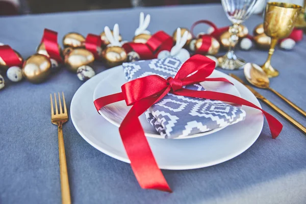 Mesa decorada con huevos de oro y cintas rojas - foto de stock