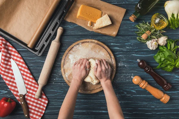 Imagen recortada de la mujer amasando masa para pizza - foto de stock