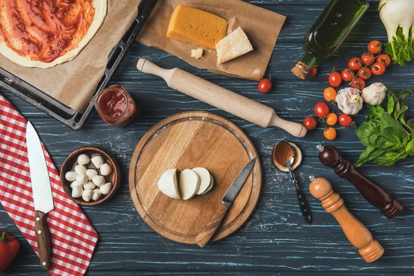 Top view of ingredients for homemade pizza on kitchen table — Stock Photo