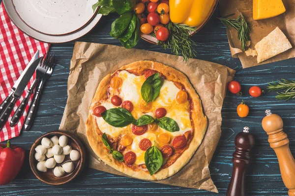 Vue de dessus de la pizza appétissante savoureuse sur la table de cuisine — Photo de stock