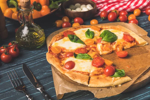 Appetitosa gustosa pizza sul tagliere su superficie in legno — Foto stock