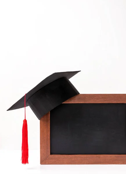 Empty blackboard with square academic cup isoalated on white — Stock Photo