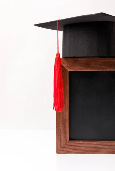 Tableau noir blanc avec tasse académique carrée isolée sur blanc — Photo de stock