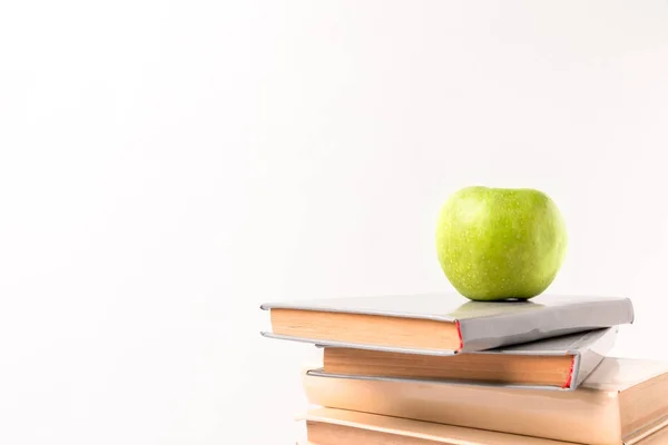 Manzana encima de la pila de libros aislados en blanco - foto de stock