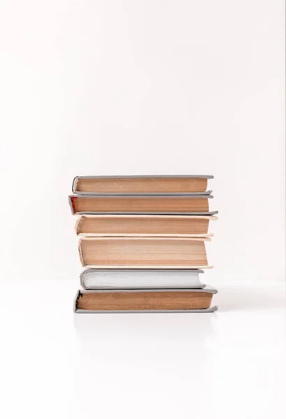 Vista frontal de pila de diferentes libros aislados en blanco - foto de stock