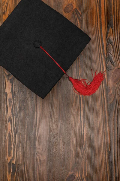 Vue du dessus de la casquette académique carrée sur fond bois — Photo de stock