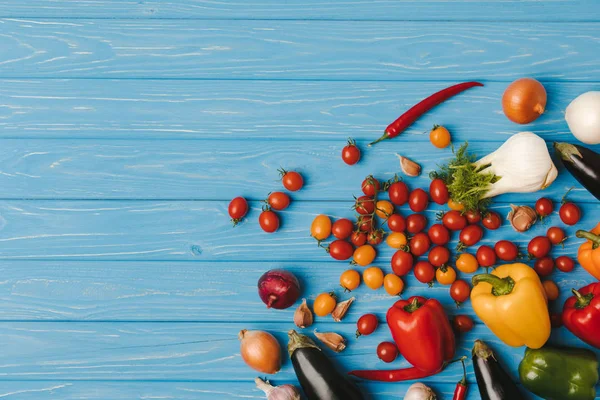 Vista superior de las verduras maduras sin procesar sobre la mesa azul - foto de stock