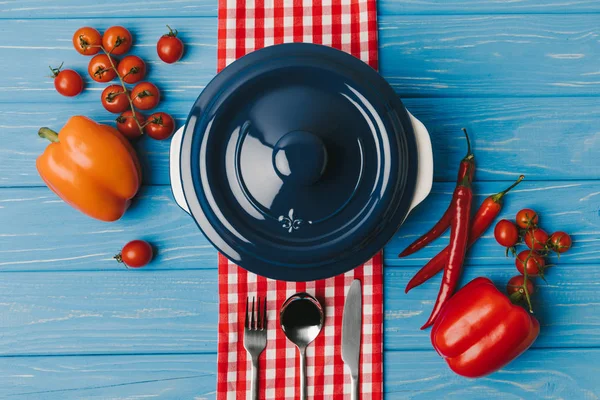 Ansicht von Pfanne und Paprika auf blauem Tisch — Stockfoto