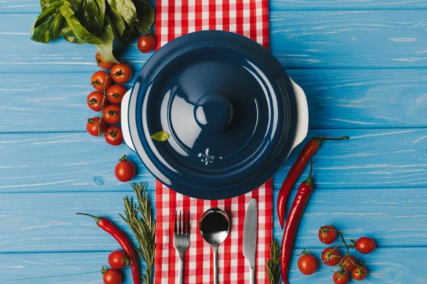 Вид зверху на синю сковороду і овочі на синьому столі — стокове фото