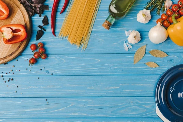 Вид ингредиентов для приготовления макарон на голубом столе — стоковое фото