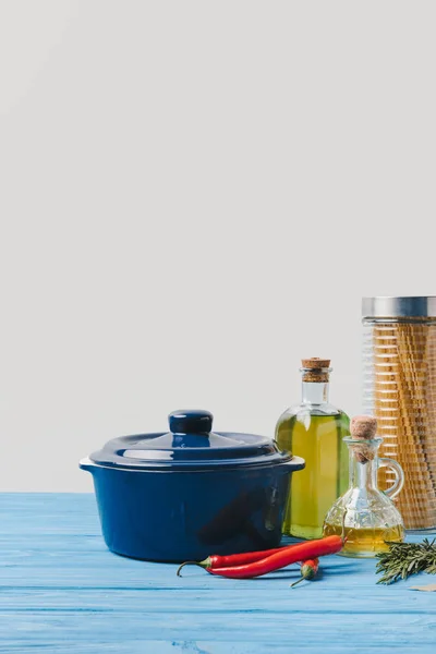 Sartén y los ingredientes para cocinar pasta en la mesa en la cocina - foto de stock