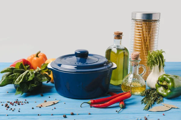 Ingredientes para cocinar pasta con verduras y sartén en la mesa - foto de stock
