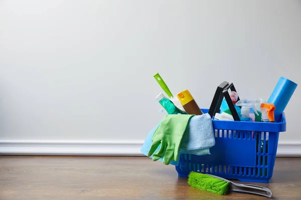 Domestic supplies for spring cleaning in basket on floor — Stock Photo