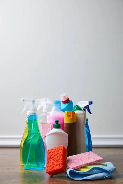 Bottles with cleaners and spray bottles on floor for spring cleaning — Stock Photo