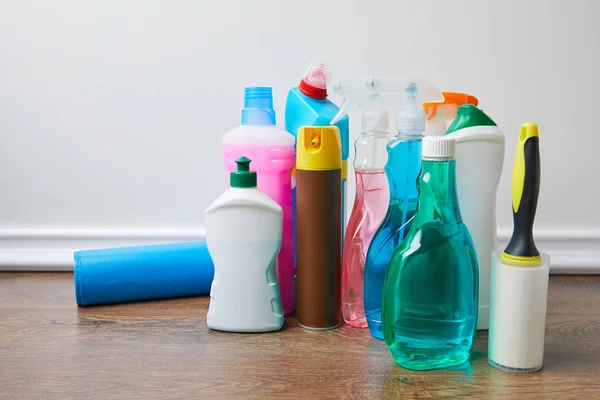 Garrafas com produtos de limpeza e frascos de spray no chão — Fotografia de Stock