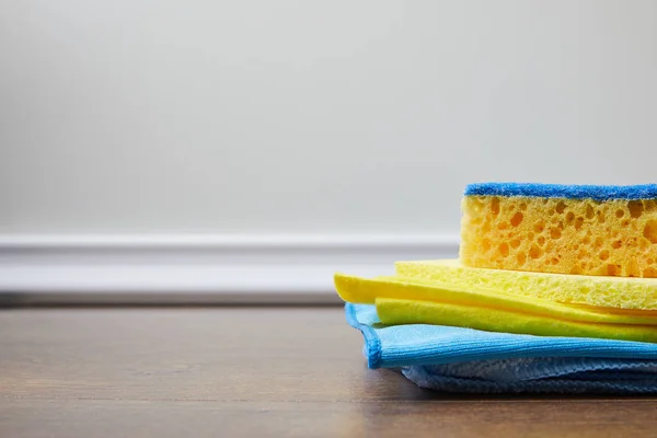 Éponge bleue et jaune et chiffons sur le sol pour le nettoyage du printemps — Photo de stock