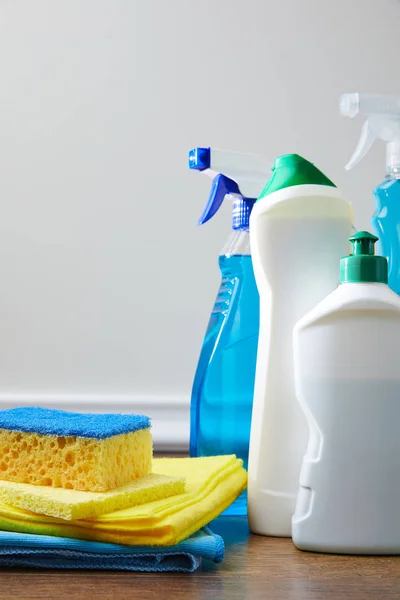 Blue and yellow sponge, rags and bottles for spring cleaning on floor — Stock Photo