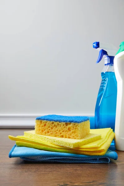 Blue and yellow sponge, rags and bottles for spring cleaning — Stock Photo