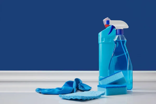 Vaporisateur, chiffons et éponges pour le nettoyage du printemps sur bleu — Photo de stock