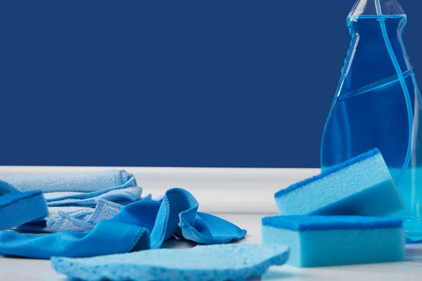 Синій спрей, ганчірки та мийні губки для весняного прибирання на підлозі — стокове фото
