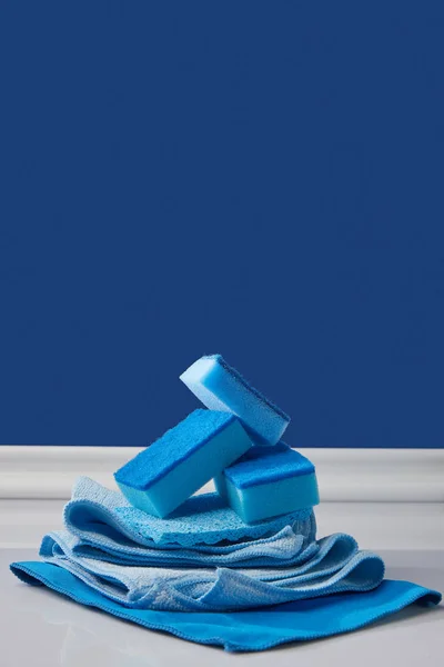 Губки та ганчірки для весняного прибирання на синьому — стокове фото