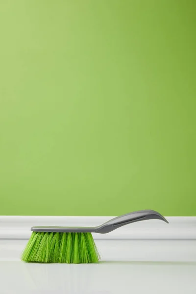 Зелена щітка для весняного прибирання на підлозі — стокове фото