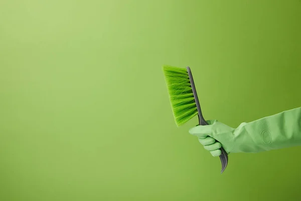 Cropped image of man holding brush for spring cleaning isolated on green — Stock Photo