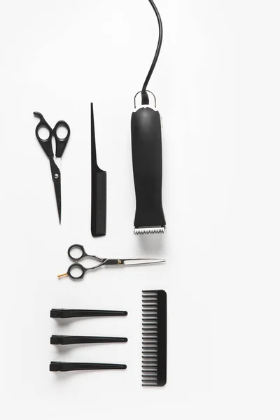 Deitado plano com cortador de cabelo e equipamento de cabeleireiro, isolado em branco — Fotografia de Stock